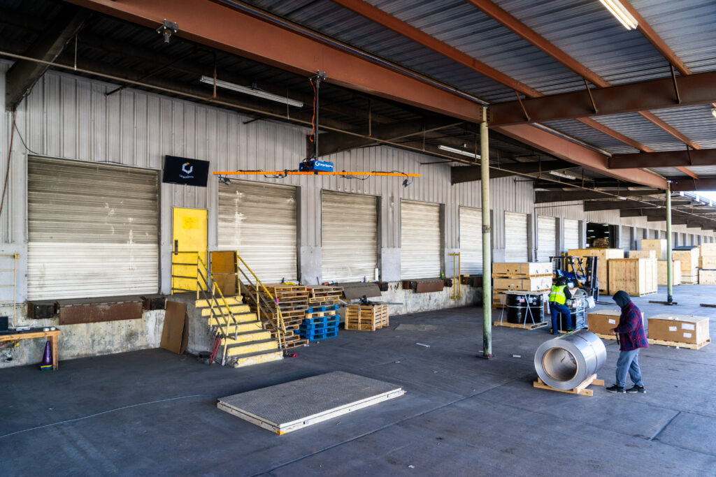 Warehouse workers use Cargo Spectre dimensionalizer for outdoor freight measurement