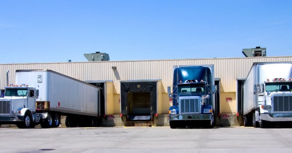 Semi trucks lined up at the loading dock of warehouse consolidators