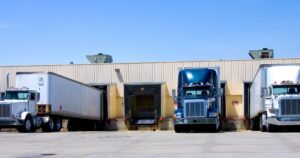 Semi trucks lined up at the loading dock of warehouse consolidators